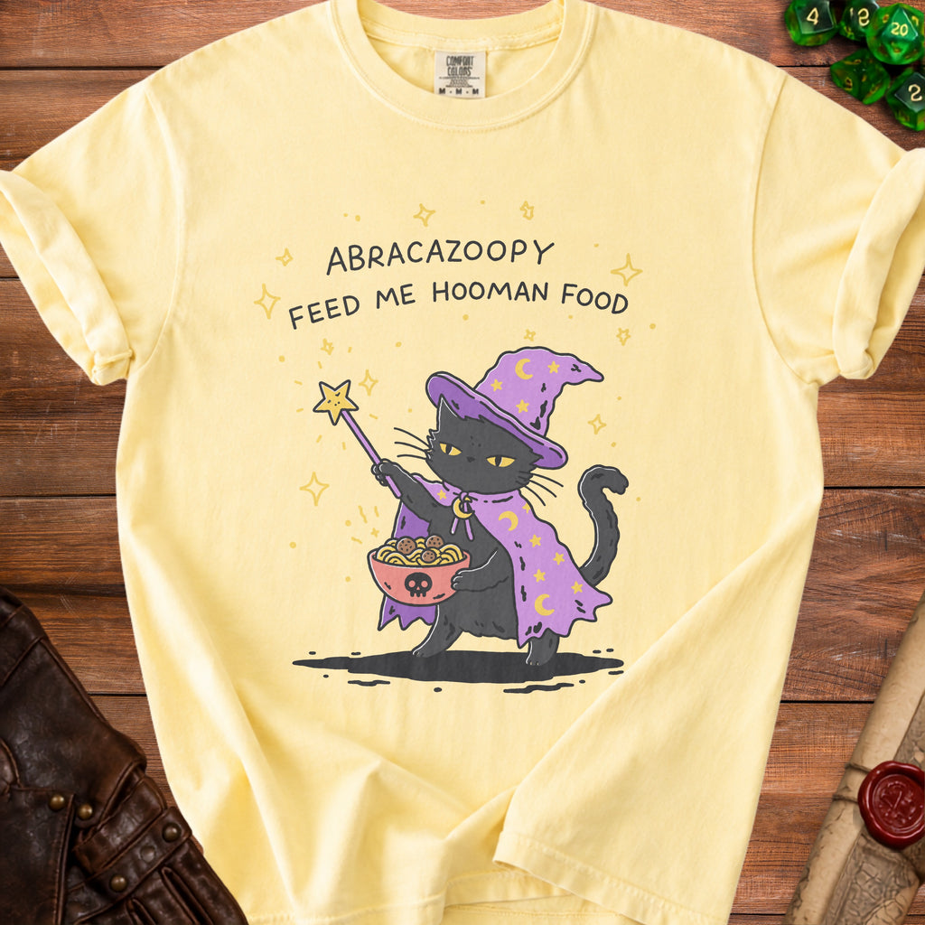 Yellow t-shirt with a cartoon black cat wizard holding spaghetti and meatballs.