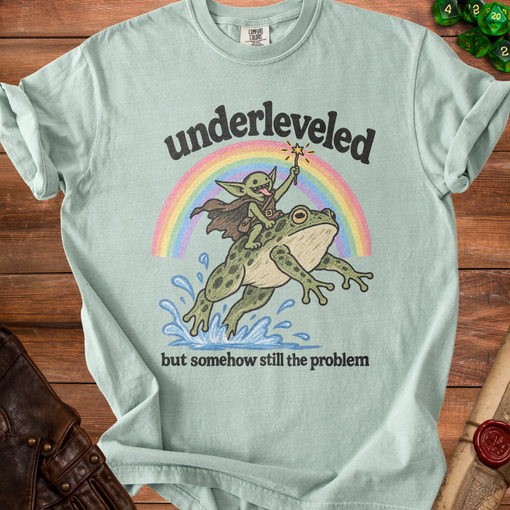 Light green t-shirt with "underleveled but somehow still the problem" graphic.