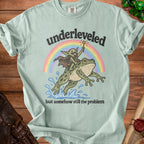 Light green t-shirt with "underleveled but somehow still the problem" graphic.