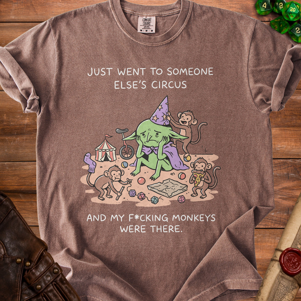 Brown t-shirt with a goblin, circus, monkeys, and dice, saying "Just went to someone else's circus and my f*cking monkeys were there."