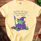 Yellow t-shirt with graphic of tired goblin wizard, "Mental HP: 2/20 Casting Spells Not Texts."