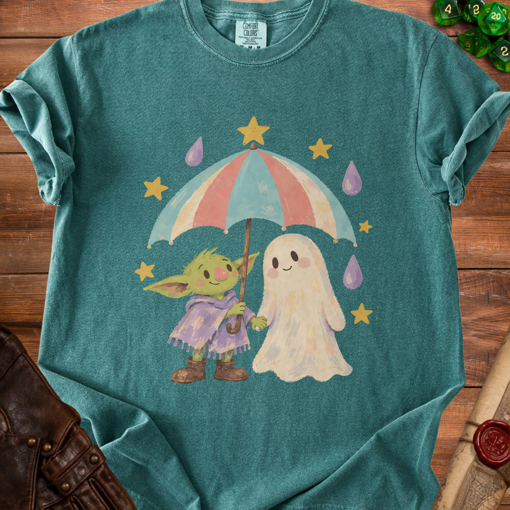 Green t-shirt with a cartoon goblin and ghost holding an umbrella in the rain.