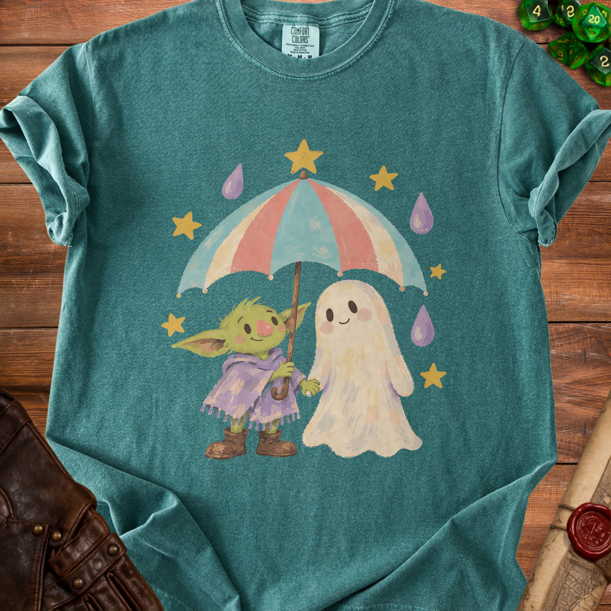 Green t-shirt with a cartoon goblin and ghost holding an umbrella in the rain.