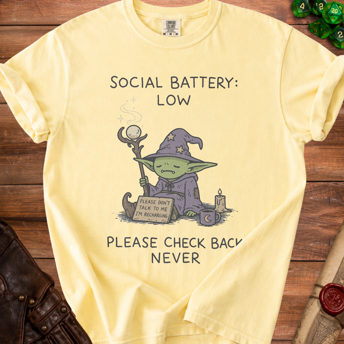 Light yellow t-shirt with a cartoon goblin and text "Social Battery: Low Please Don't Talk To Me I'm Recharging Please Check Back Never".