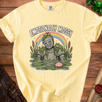 Yellow t-shirt graphic of a moss-covered knight in a pond with a frog and text "Emotionally Mossy".