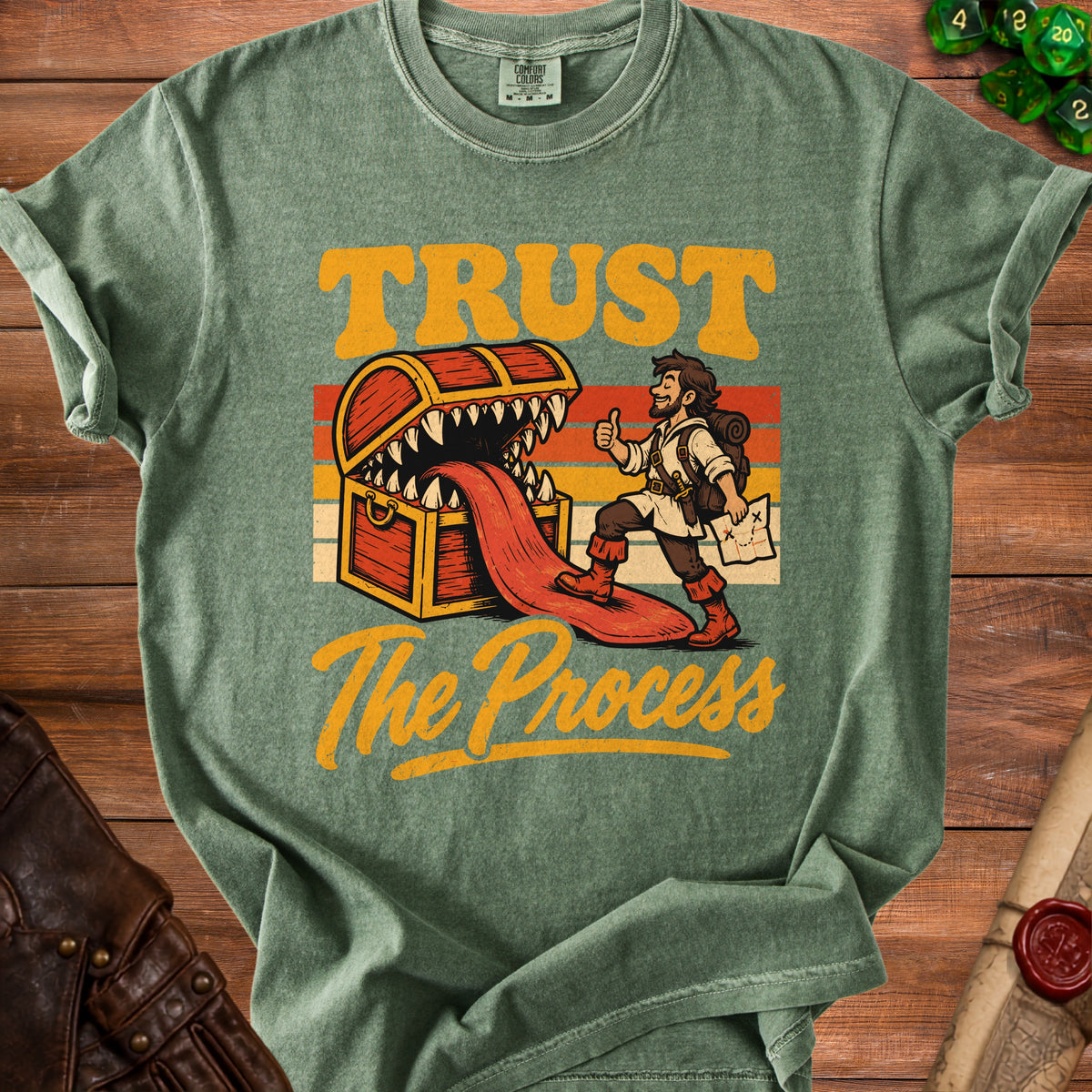 Green t-shirt with "TRUST The Process" text and illustration of a treasure chest.