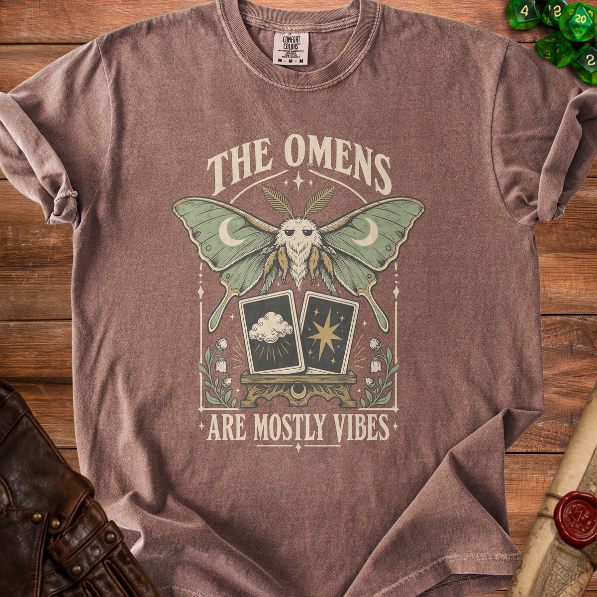 Brown t-shirt with moth, tarot cards, and text "The Omens Are Mostly Vibes".