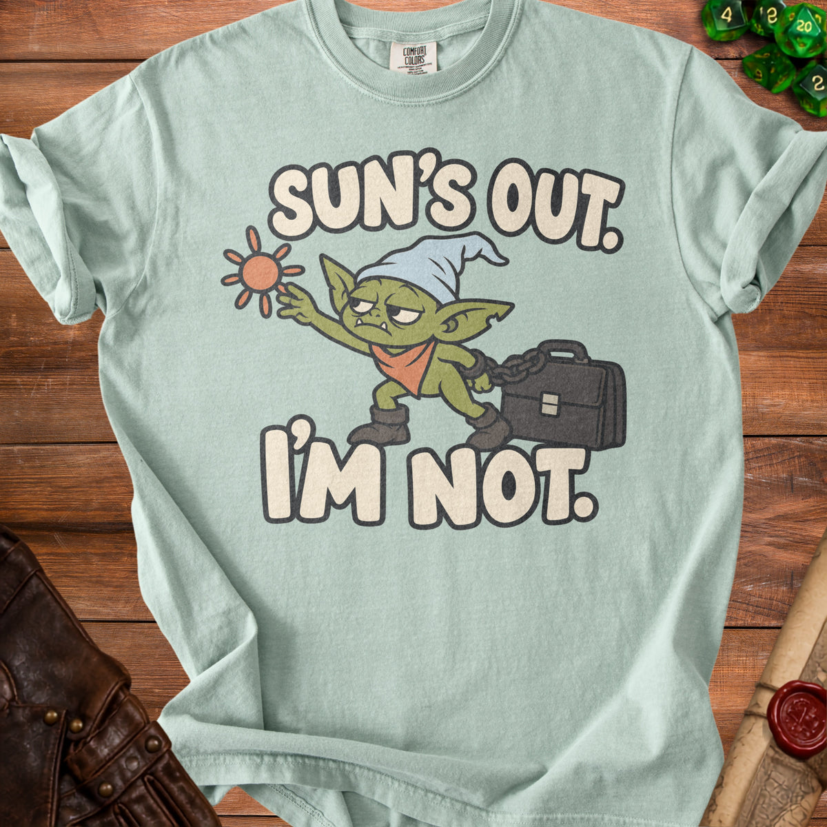 Mint green t-shirt with a goblin graphic and text "Sun's Out. I'm Not."