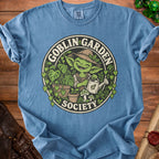 Goblin Garden Society graphic on a blue t-shirt featuring a gardening goblin.