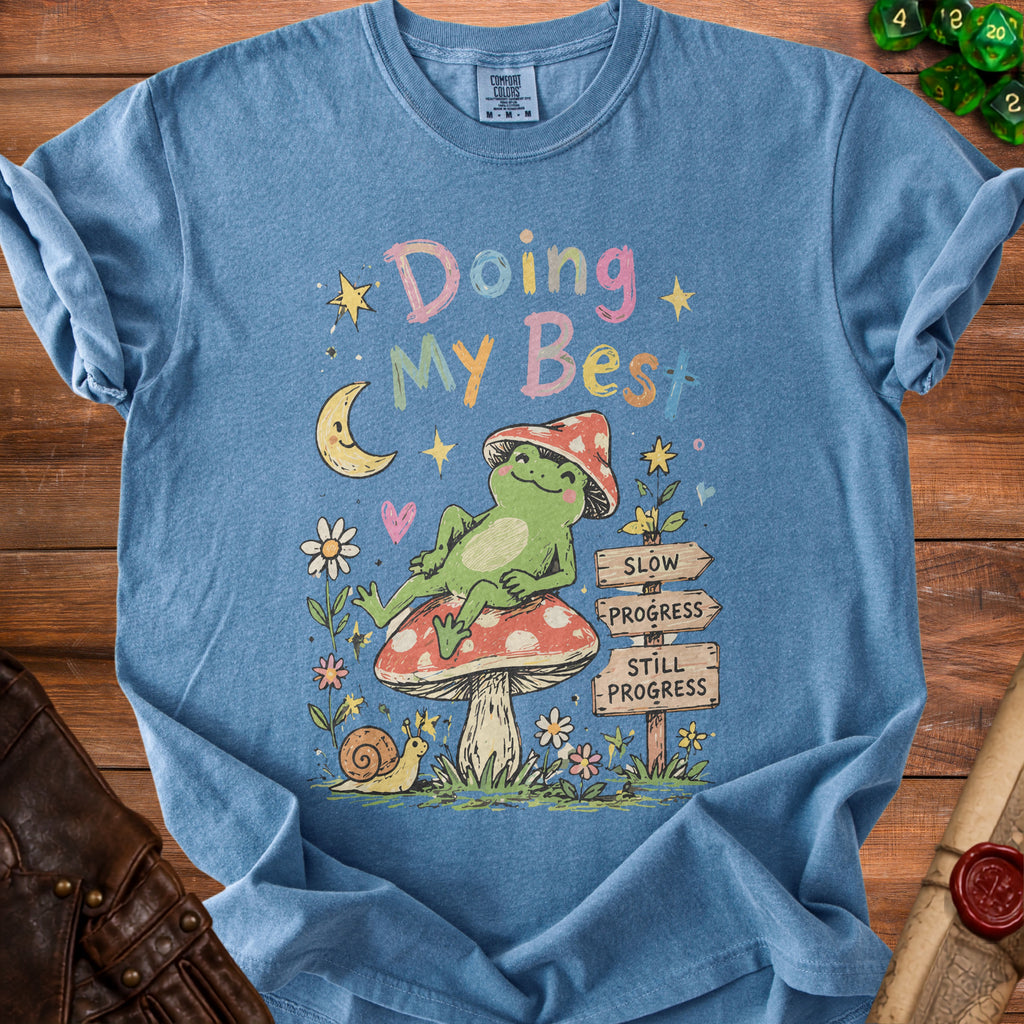Blue t-shirt with a graphic of a frog on a mushroom and text "Doing My Best".