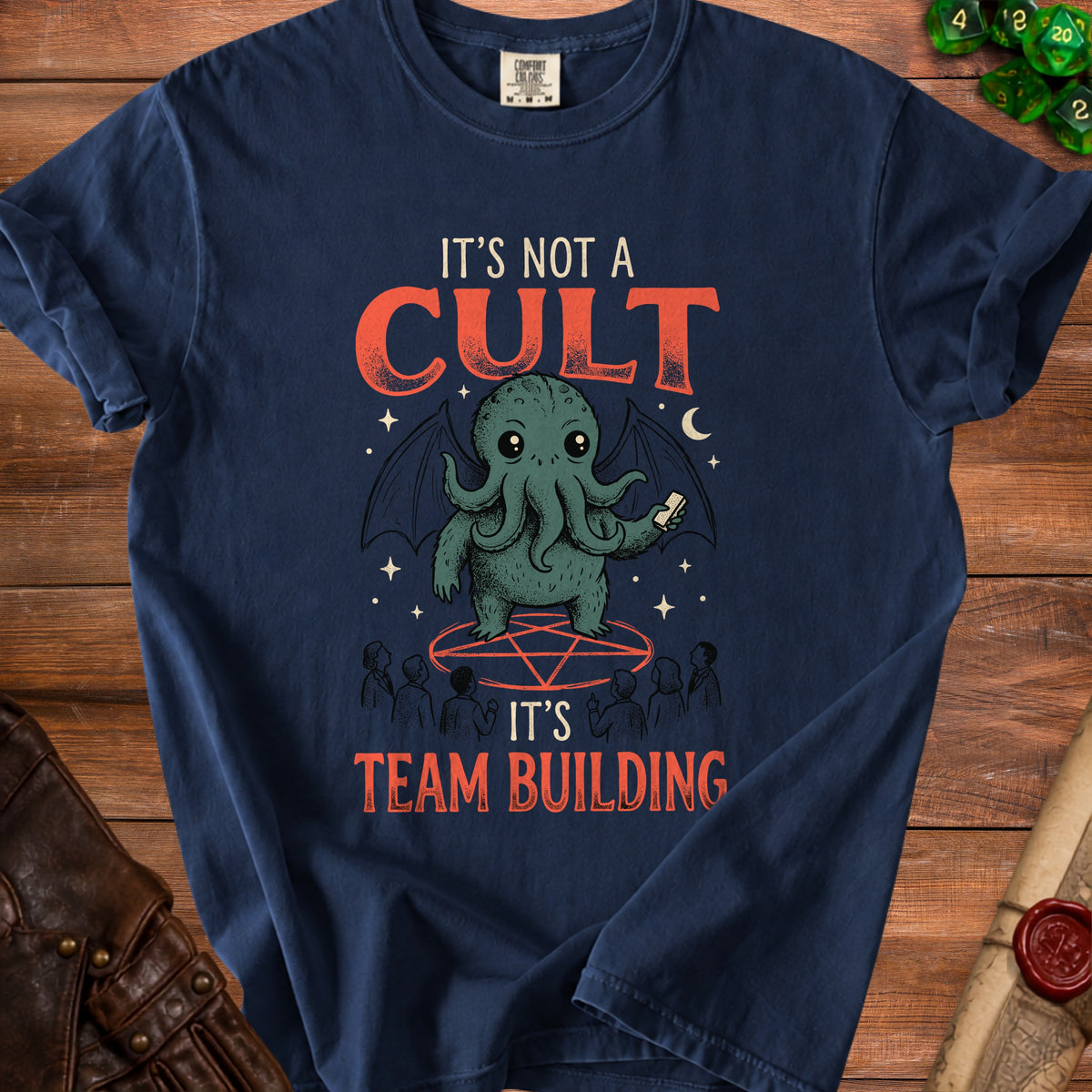 Dark blue t-shirt graphic with text "IT'S NOT A CULT IT'S TEAM BUILDING" and Cthulhu.