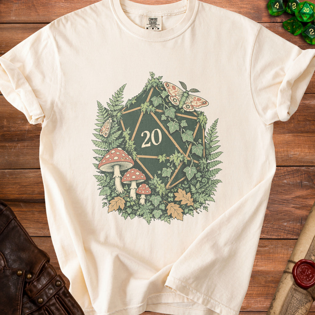 Cream t-shirt with a twenty-sided die surrounded by mushrooms, ferns, ivy, and moths.