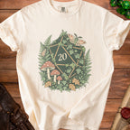 Cream t-shirt with a twenty-sided die surrounded by mushrooms, ferns, ivy, and moths.