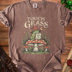 Brown t-shirt with frog in wizard hat holding sign saying "Touch Grass But Make It Magical".