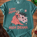 Green t-shirt with a witch graphic and text "Low Mana High Drama".