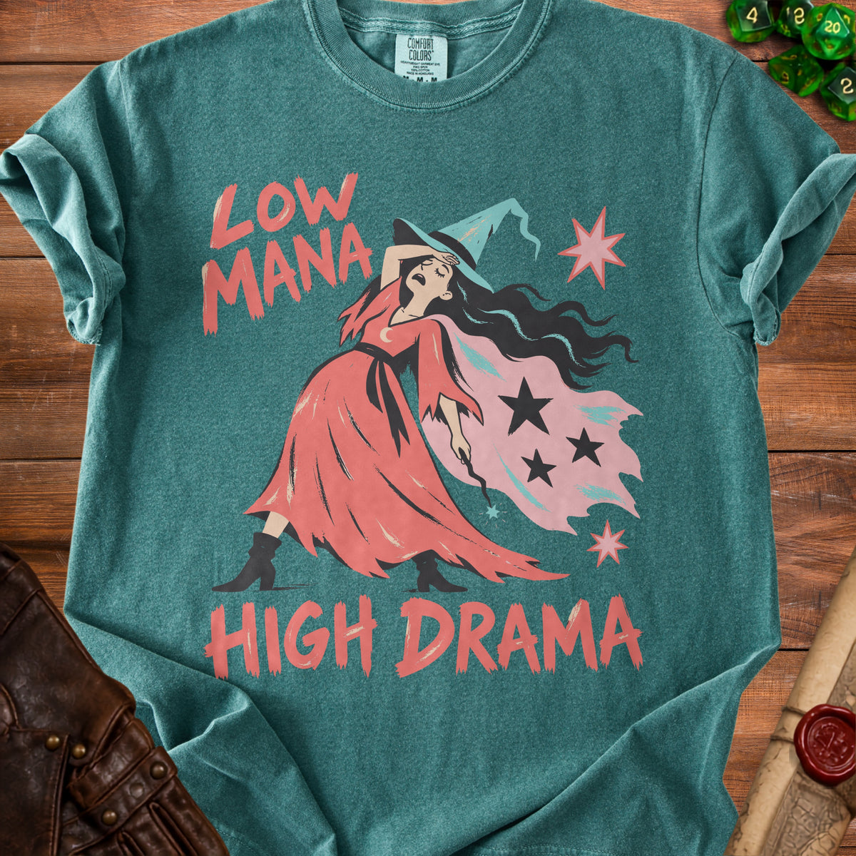 Green t-shirt with a witch graphic and text "Low Mana High Drama".
