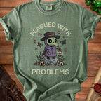Green t-shirt with plague doctor graphic and text "PLAGUED WITH PROBLEMS".