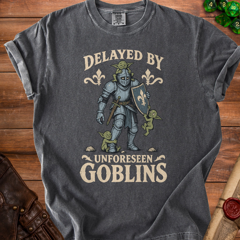 Dark grey t-shirt with knight, goblins, and text "Delayed by Unforeseen Goblins".