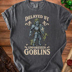 Dark grey t-shirt with knight, goblins, and text "Delayed by Unforeseen Goblins".