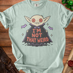 Light green t-shirt with a cartoon vampire graphic and "I'M NOT THAT WEIRD" text.