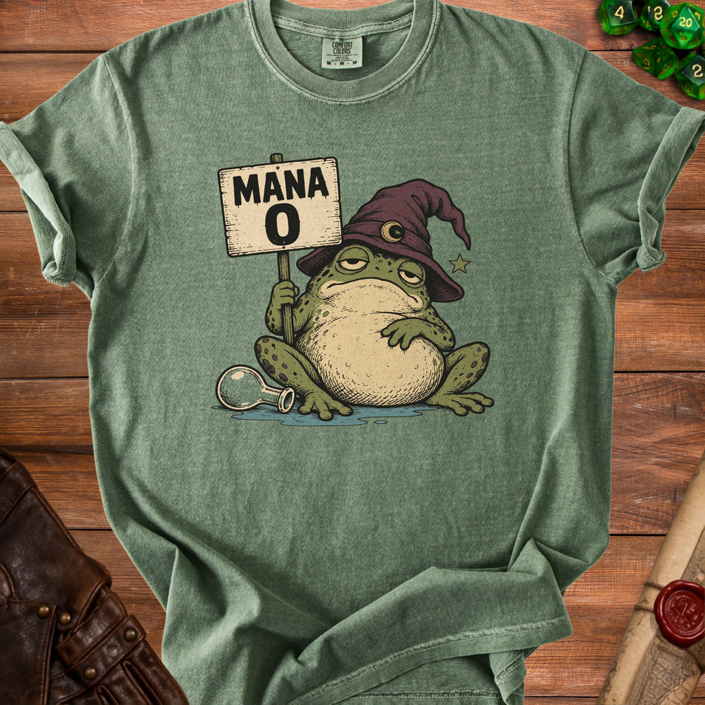 An olive green t-shirt featuring a graphic of a sleepy frog wearing a wizard hat and holding a sign that says MANA 0.