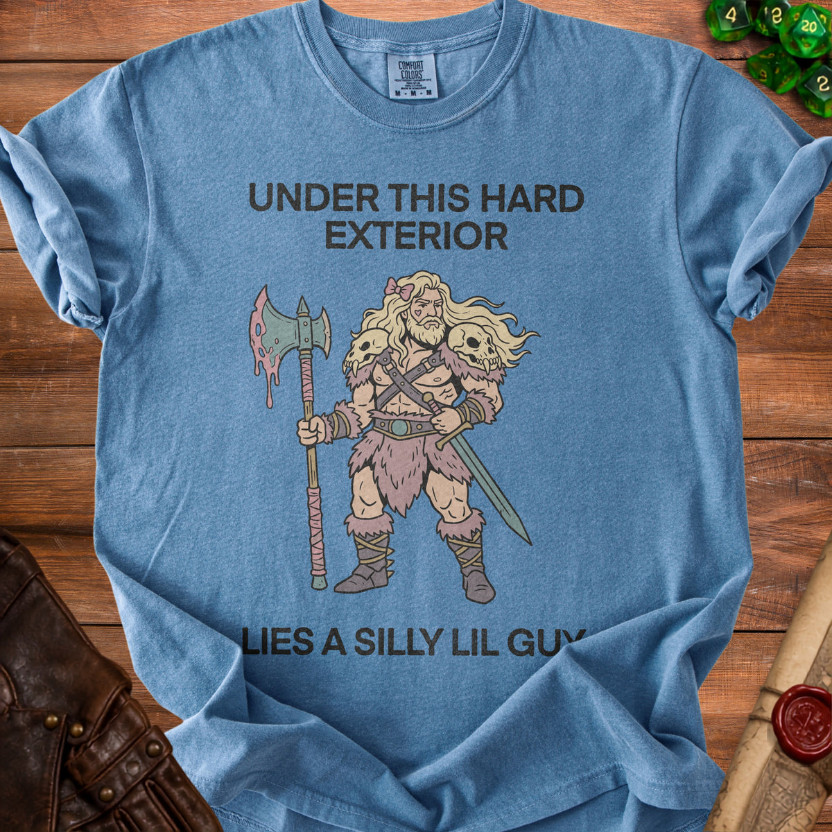 Blue t-shirt with "Under This Hard Exterior Lies a Silly Lil Guy" and barbarian illustration.