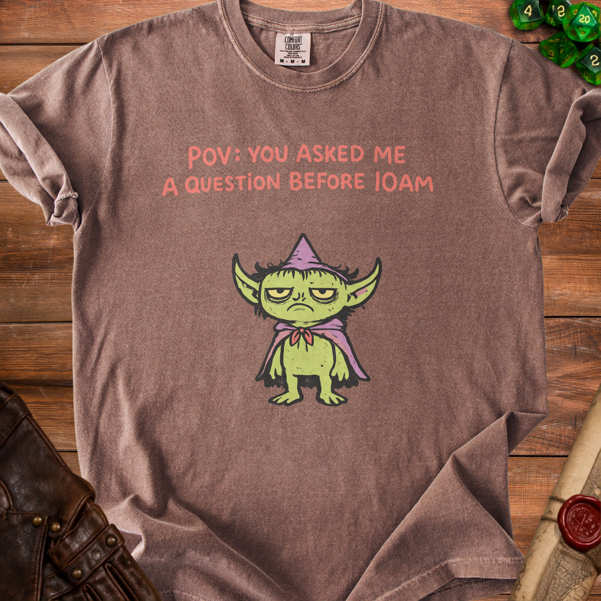 Brown t-shirt with a grumpy goblin and text "POV: YOU ASKED ME A QUESTION BEFORE 10AM".