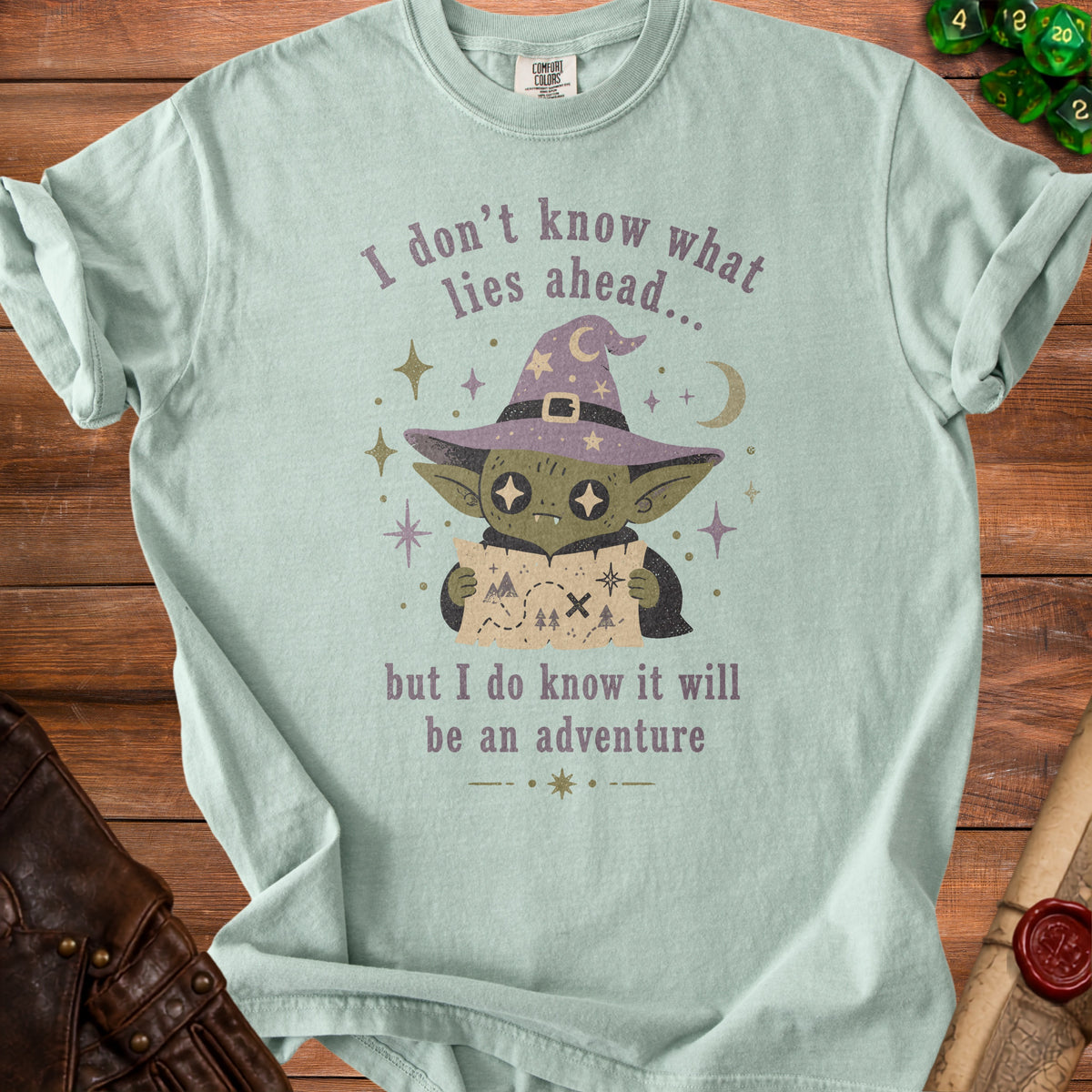 Light green t-shirt with a goblin wizard and the text "I don't know what lies ahead... but I do know it will be an adventure".