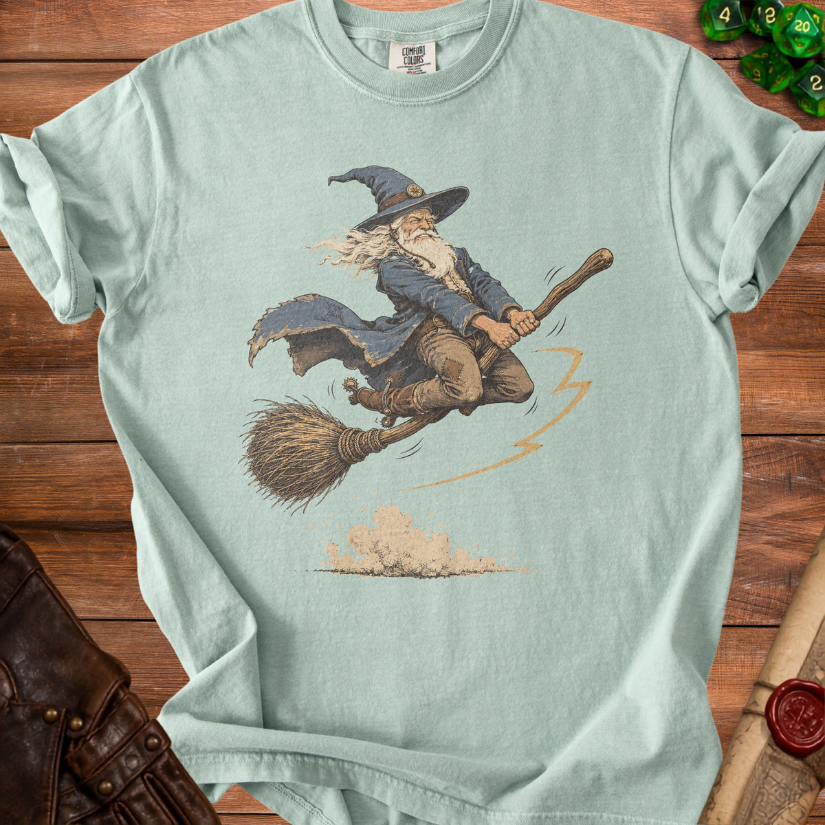 Light green t-shirt with a wizard flying on a broomstick, with dust clouds below.