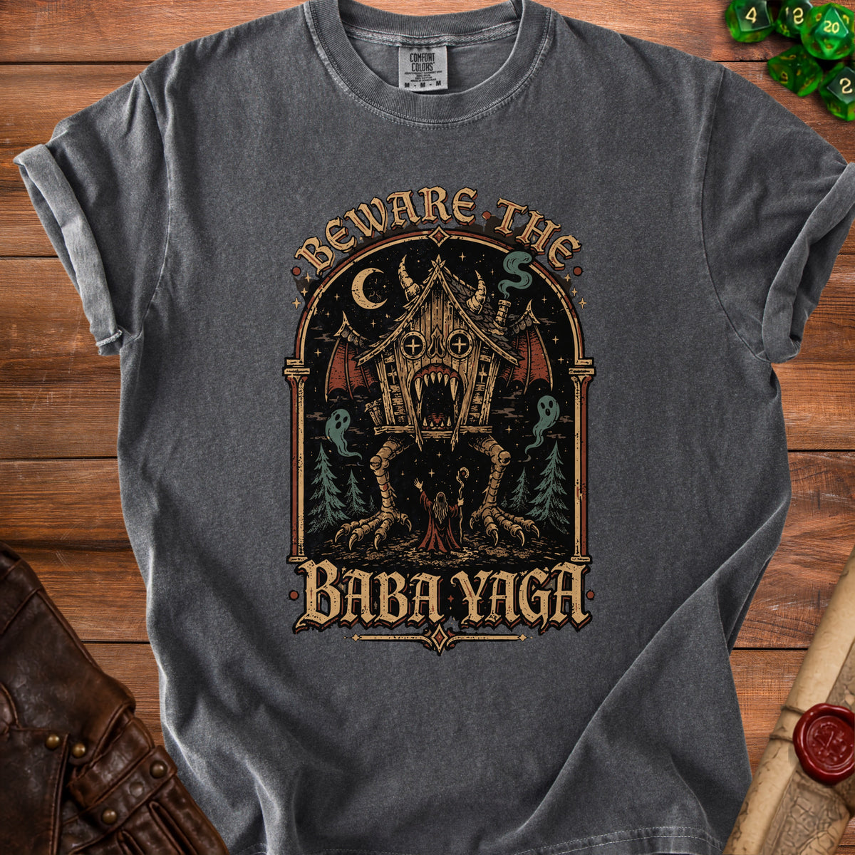 Dark gray t-shirt with a graphic of a house on legs with fangs and text "Beware the Baba Yaga".