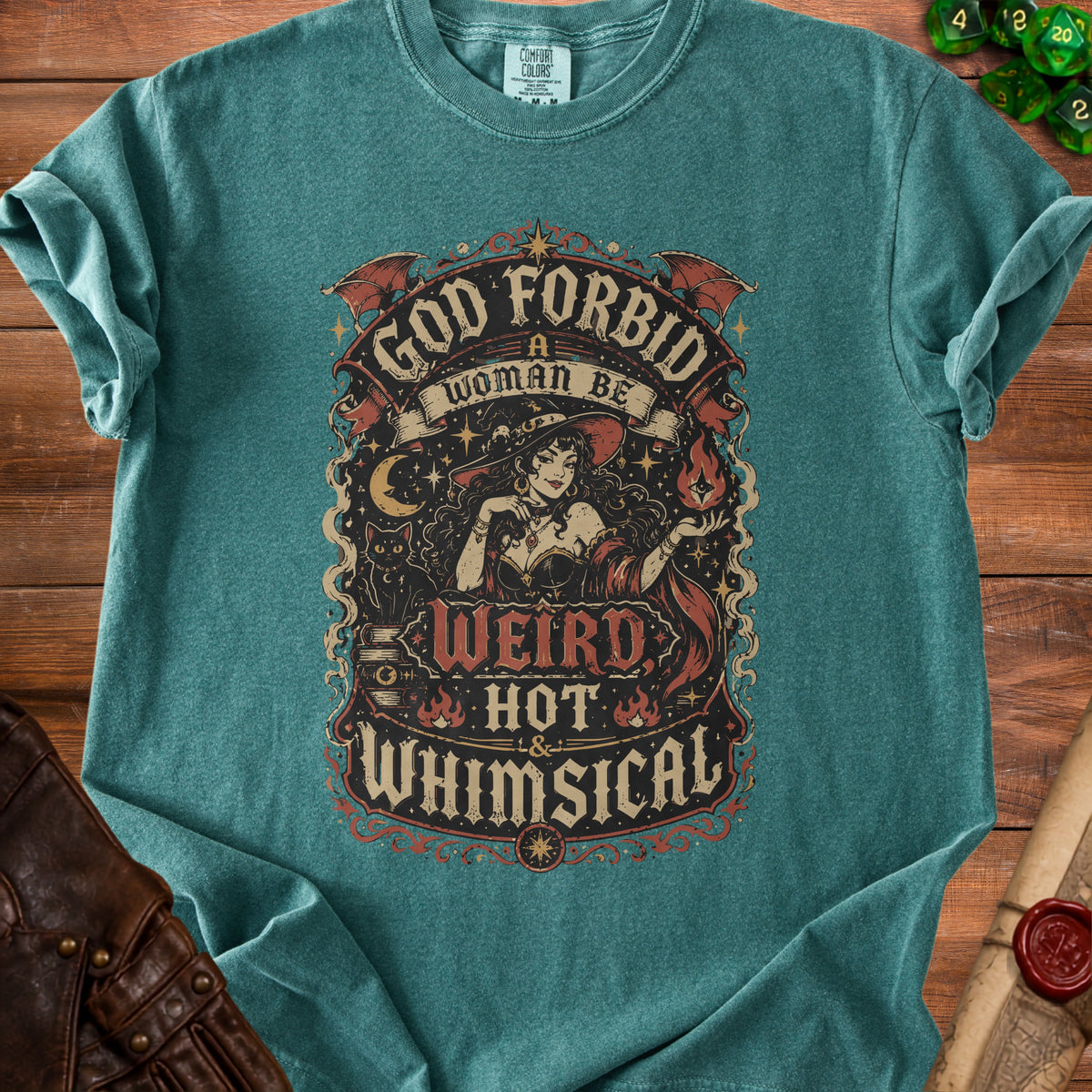 Teal t-shirt with "God Forbid A Woman Be Weird, Hot & Whimsical" graphic featuring a witch.