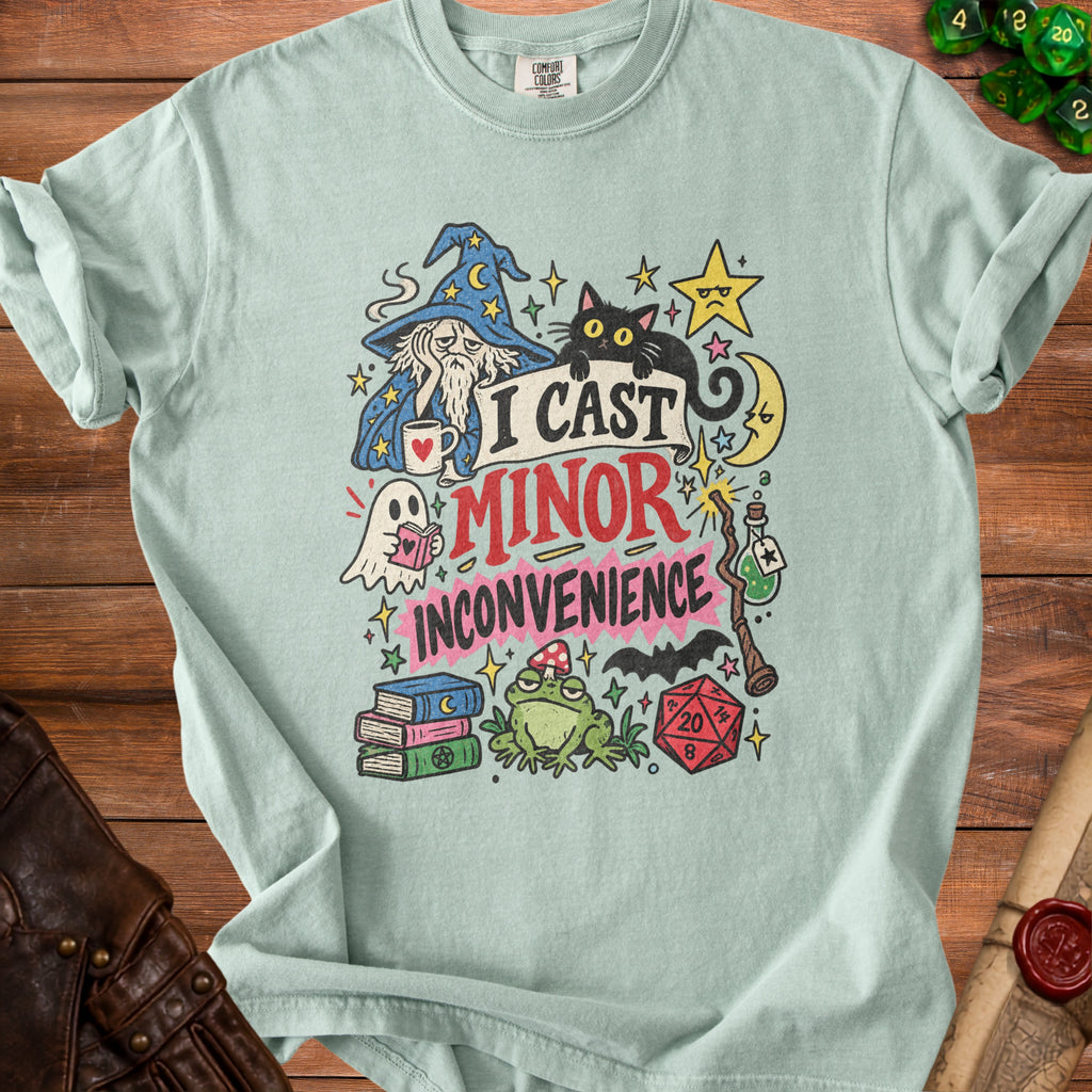 Light teal t-shirt with fantasy graphics and text "I Cast Minor Inconvenience".