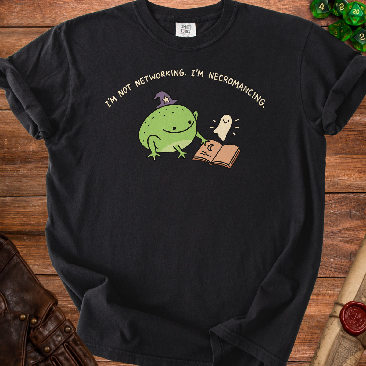 Black t-shirt with a cartoon frog in a witch hat, a ghost, and an open book.