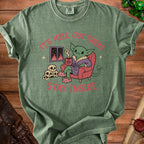 Green t-shirt with a goblin holding coffee, skulls, and text "It's hell out there stay inside".