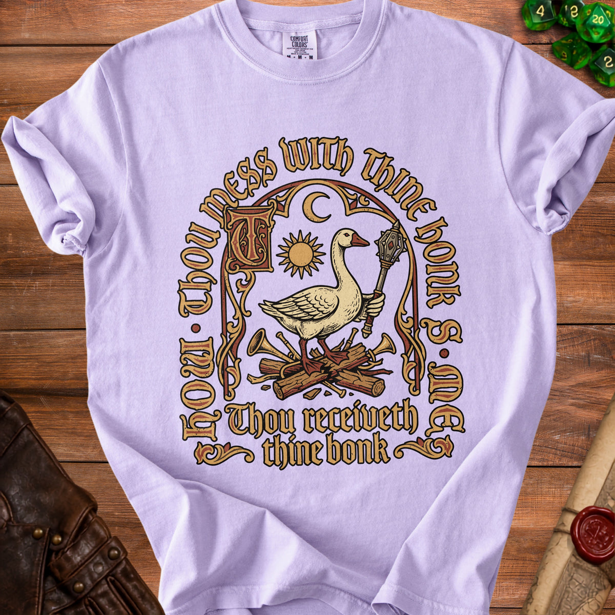 Light purple t-shirt with graphic of goose holding mace, sun, moon, and text.