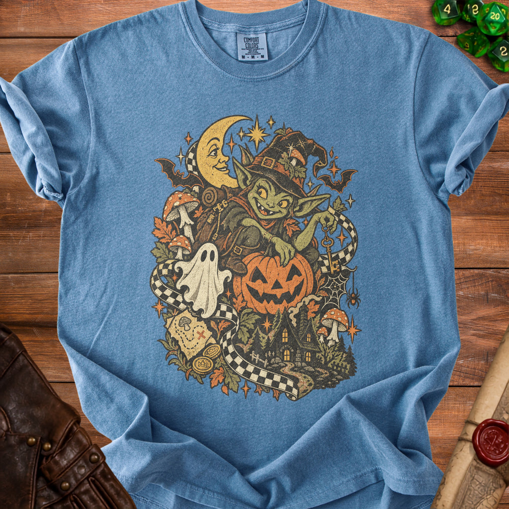 Goblin witch with pumpkin, ghost, moon, and haunted house graphic on blue t-shirt.
