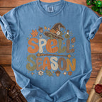 Blue t-shirt with "SPELL SEASON" text in decorative font, witch hat, and fall accents.