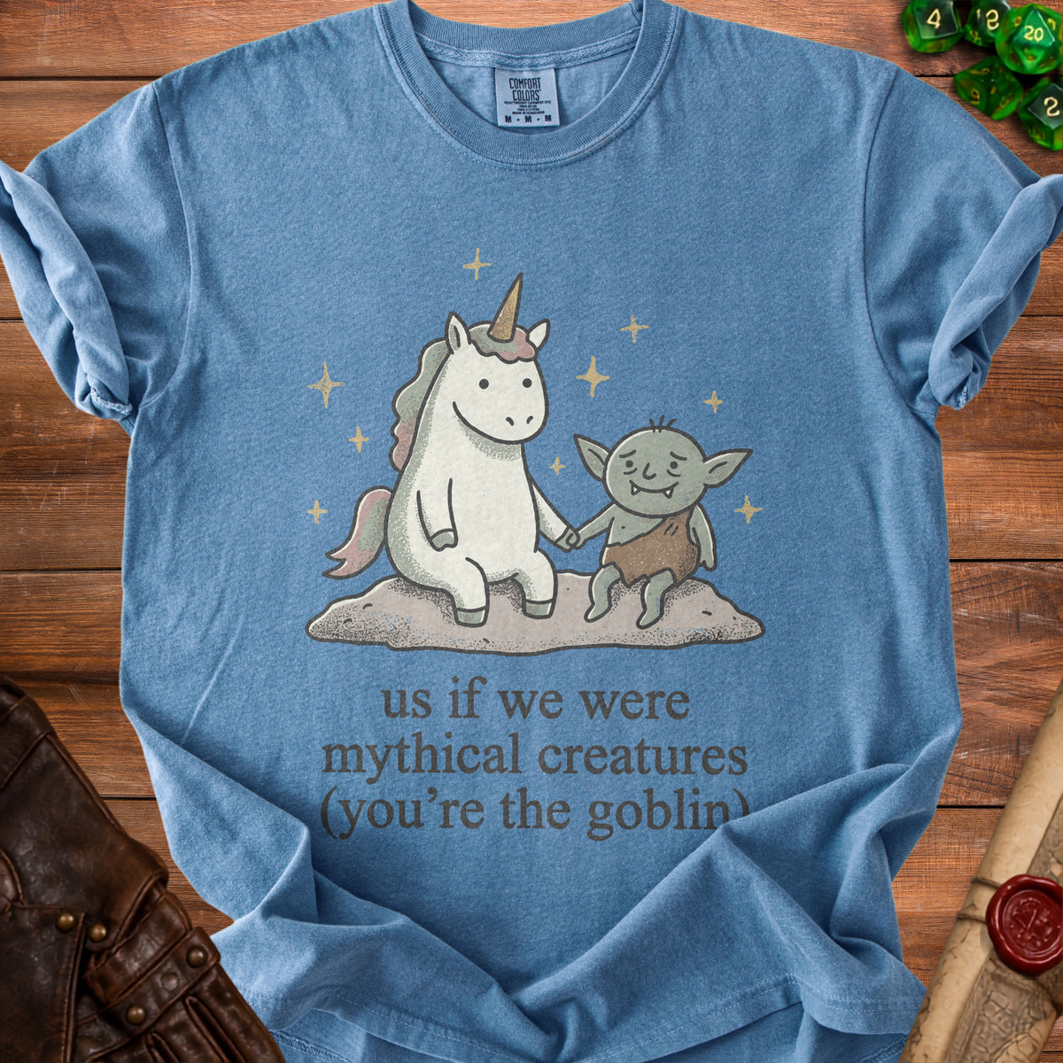 Blue t-shirt with a unicorn and goblin graphic and text "us if we were mythical creatures (you're the goblin)".