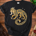 Black t-shirt featuring a golden fantastical creature with blue floral patterns and a crescent moon.