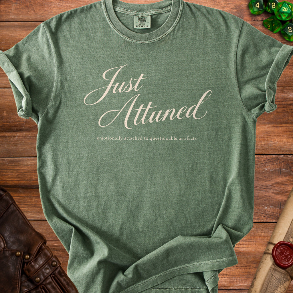 Green t-shirt with "Just Attuned" and "emotionally attached to questionable artifacts" text.