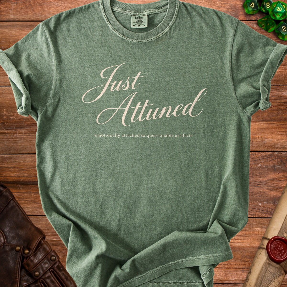 Green t-shirt with "Just Attuned" and "emotionally attached to questionable artifacts" text.