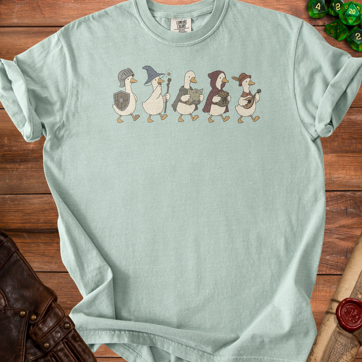 Light mint t-shirt with five cartoon ducks dressed as fantasy characters.