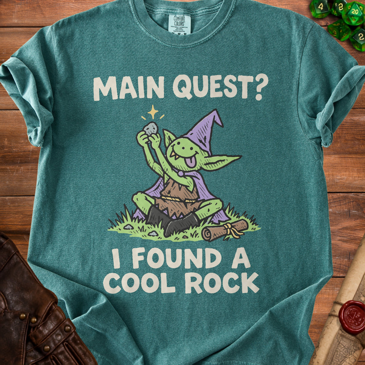 Green t-shirt with a goblin holding a rock, text reads "Main Quest? I Found a Cool Rock."