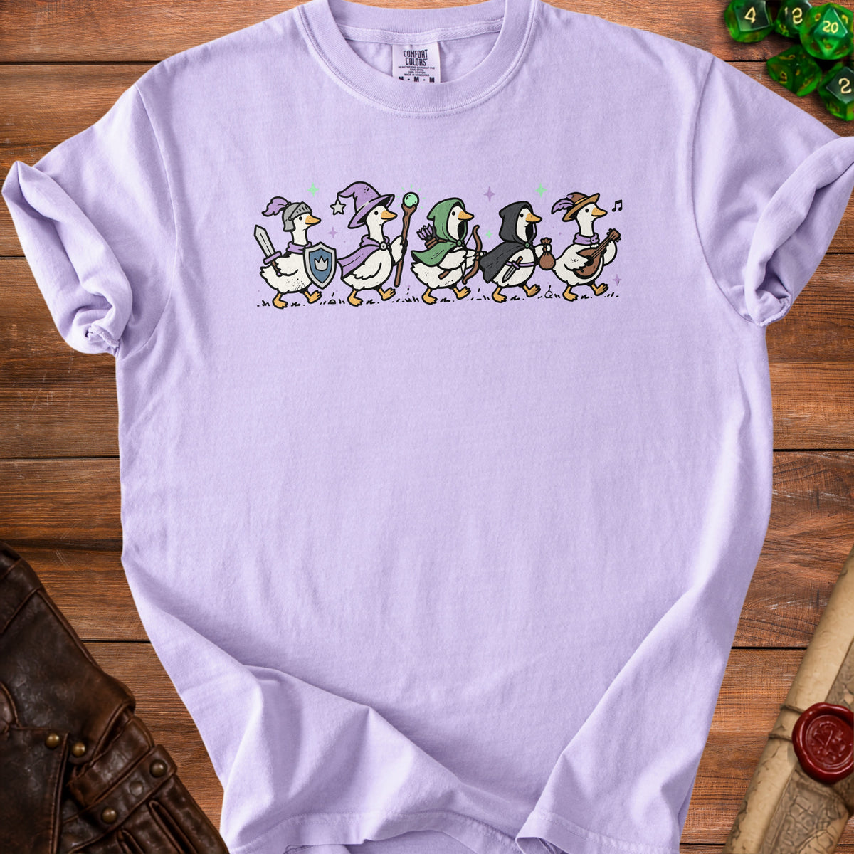 Lavender t-shirt with illustrated fantasy geese characters walking in a line.