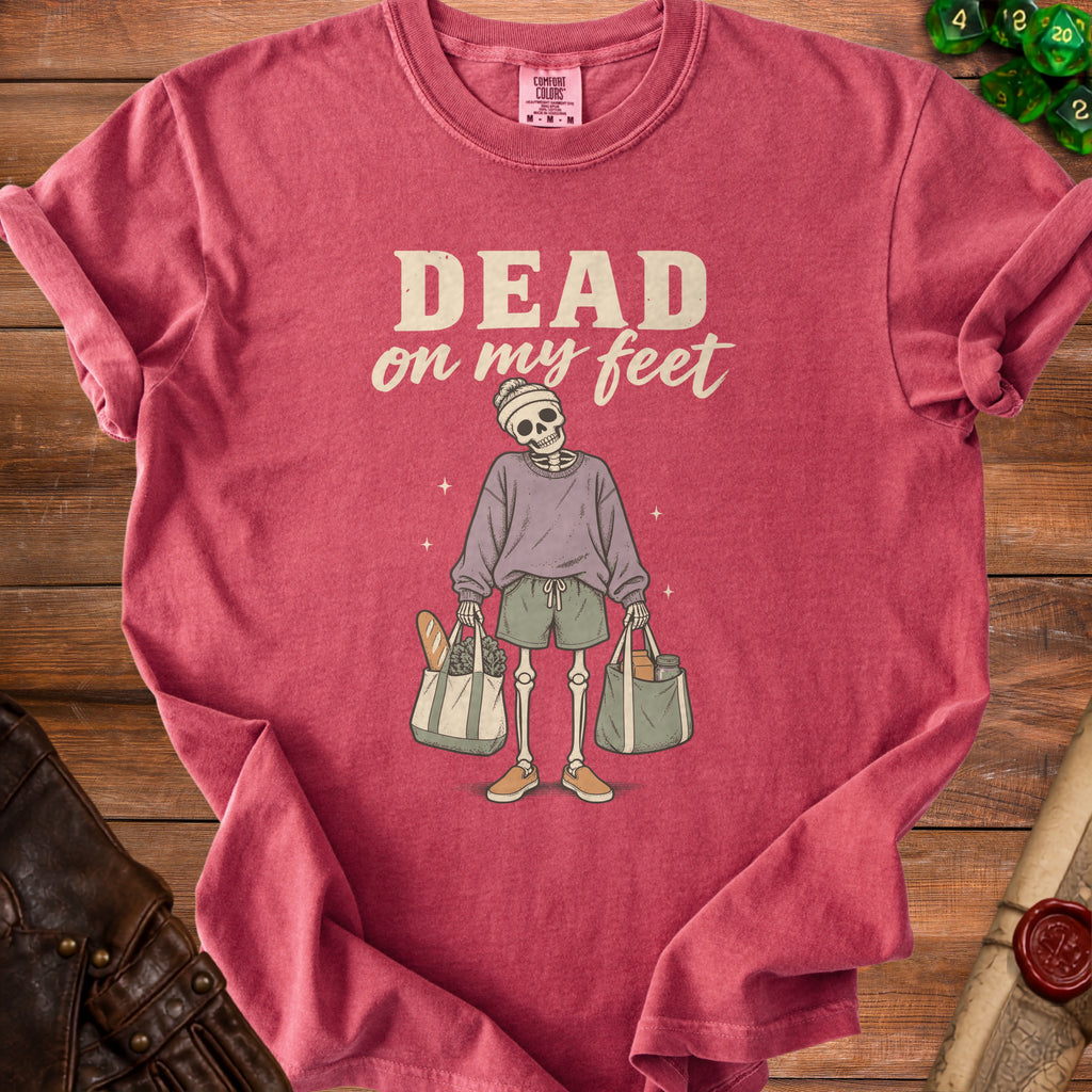 T-shirt with skeleton graphic and text "DEAD on my feet" holding shopping bags.