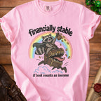 Pink t-shirt with raccoon riding a treasure chest, saying "financially stable if loot counts as income".