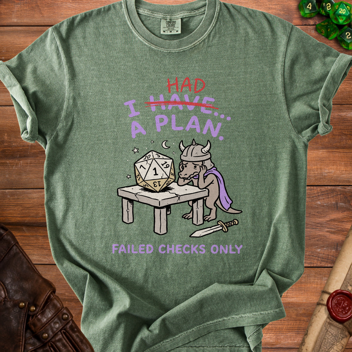 Green t-shirt with a dragon character, dice, and text that reads "I HAD A PLAN... FAILED CHECKS ONLY."