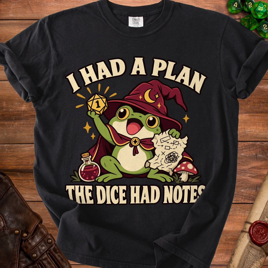 A black t-shirt featuring a green frog wizard holding a critical fail die with text reading I HAD A PLAN THE DICE HAD NOTES.