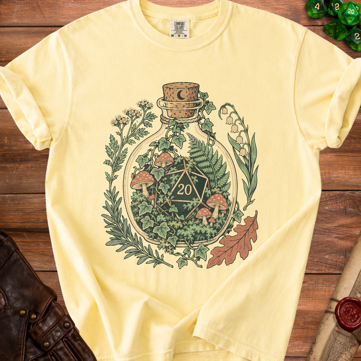 Pale yellow t-shirt with a D20 die and forest elements inside a bottle.
