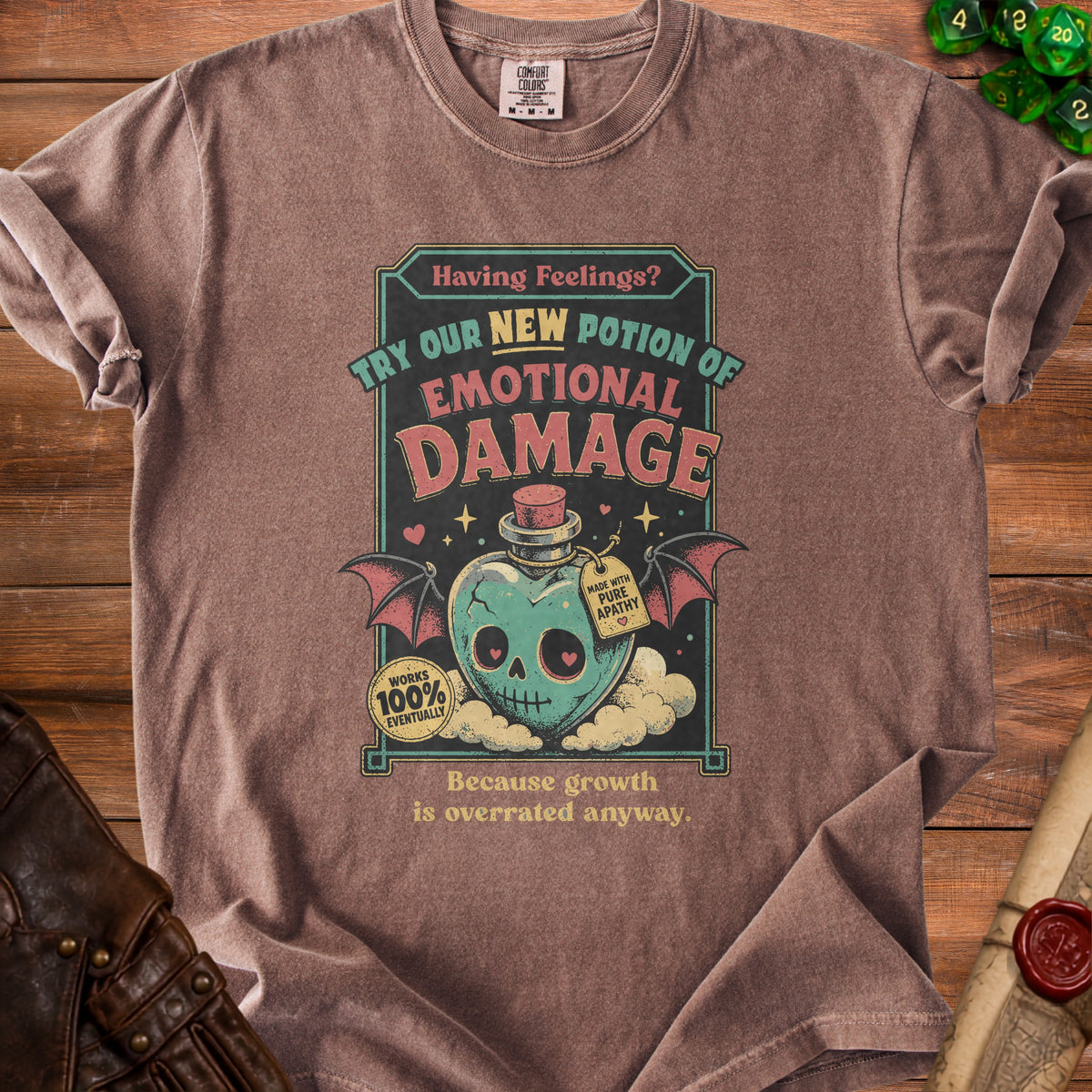 Brown t-shirt with "Emotional Damage" potion graphic and text "Because growth is overrated anyway."